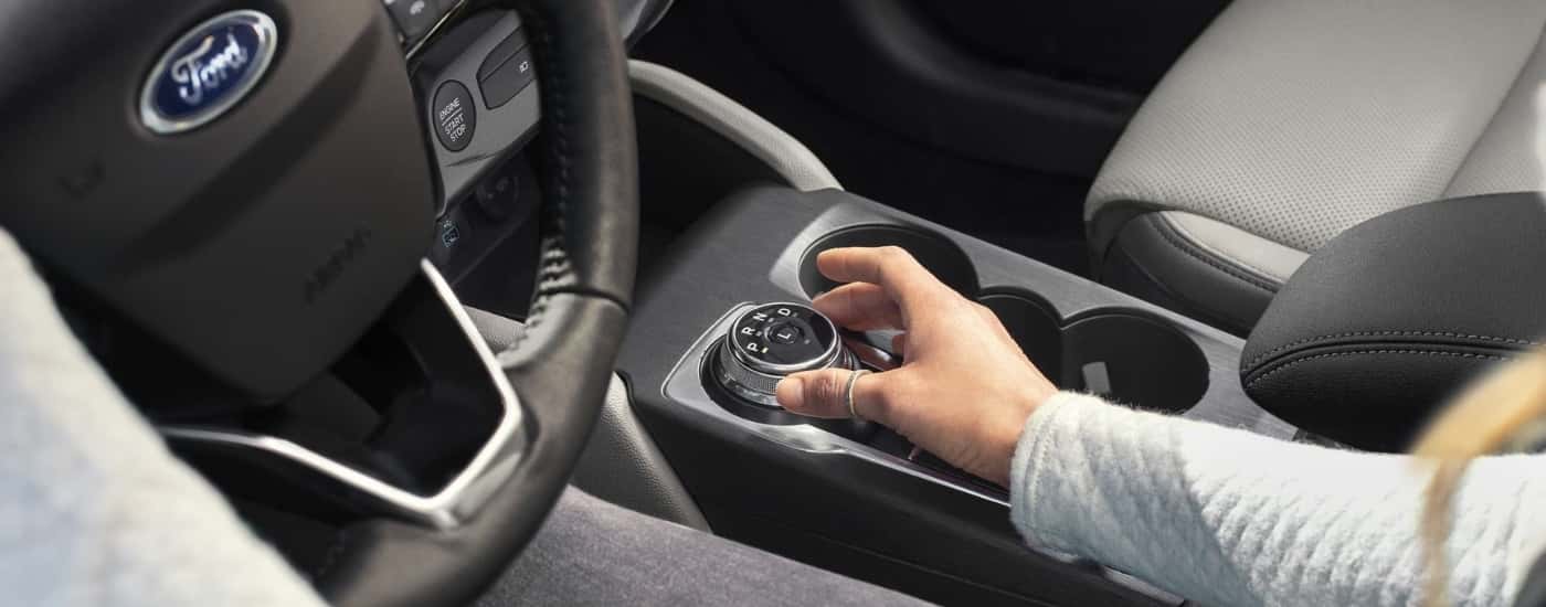 A person is shown using the shift knob in a 2025 Ford Escape.