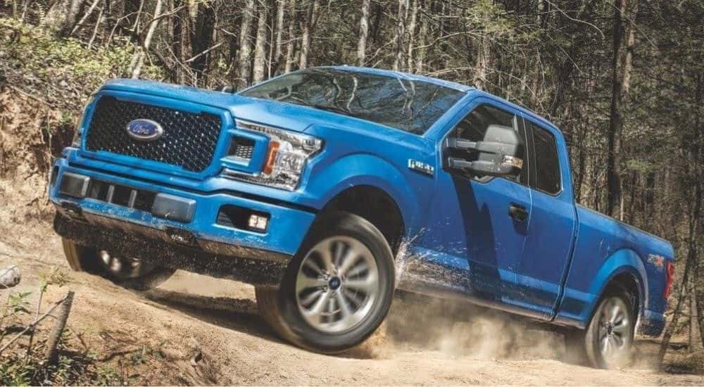 A blue 2018 Ford F-150 for sale near Lawrenceville is shown off-roading.