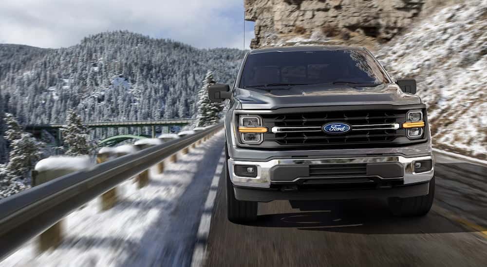 Front angle view of a grey 2025 Ford F-150 driving on a mountain road.