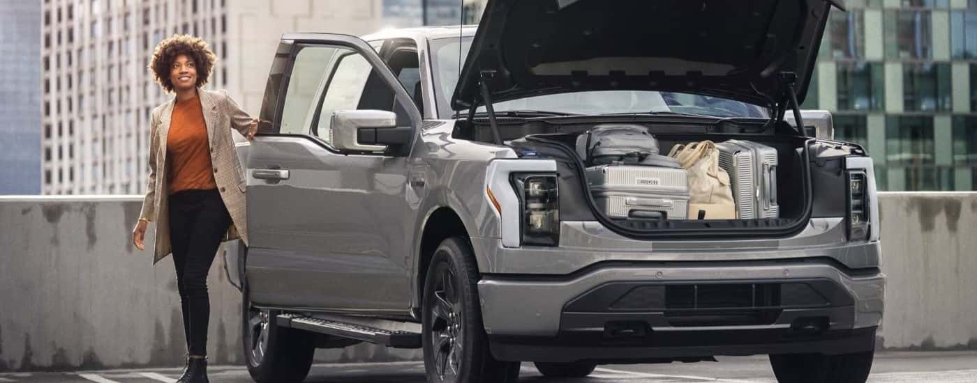 A person is shown next to a silver 2023 Ford F-150 Lightning after leaving a Ford Lightning dealer.