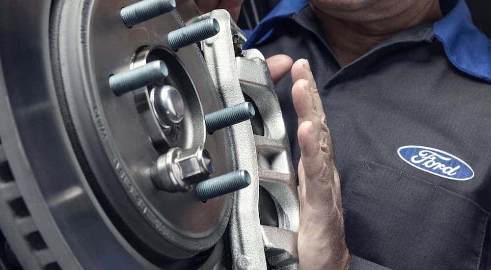 A Ford mechanic near you is shown working on a caliper.
