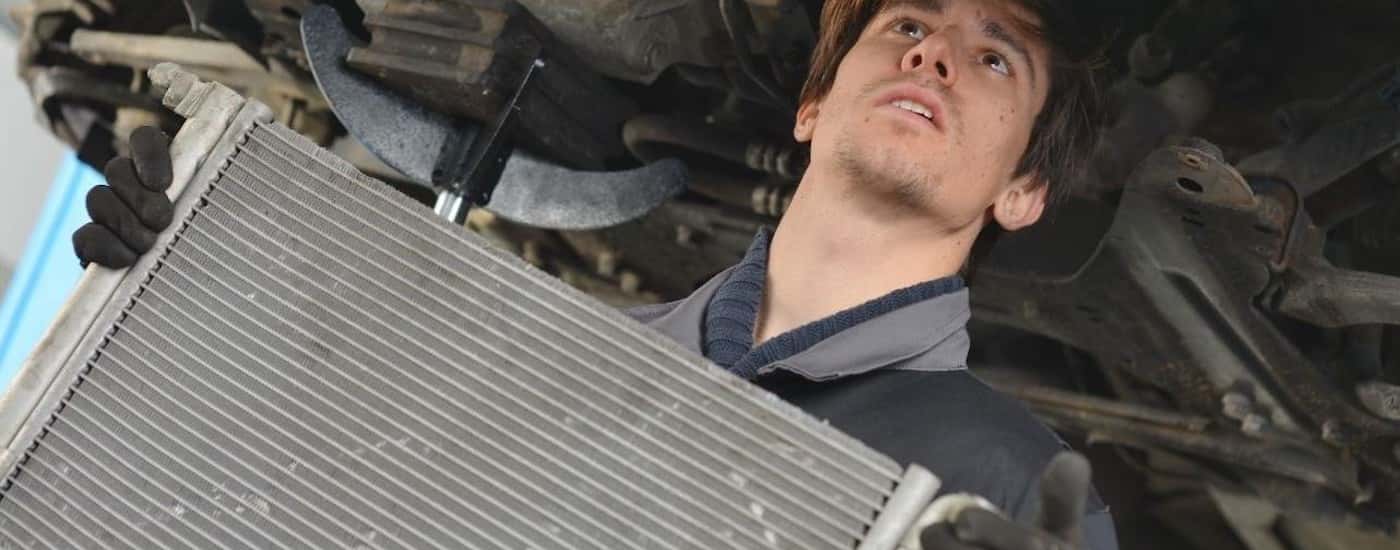 A mechanic is shown during a radiator repair.