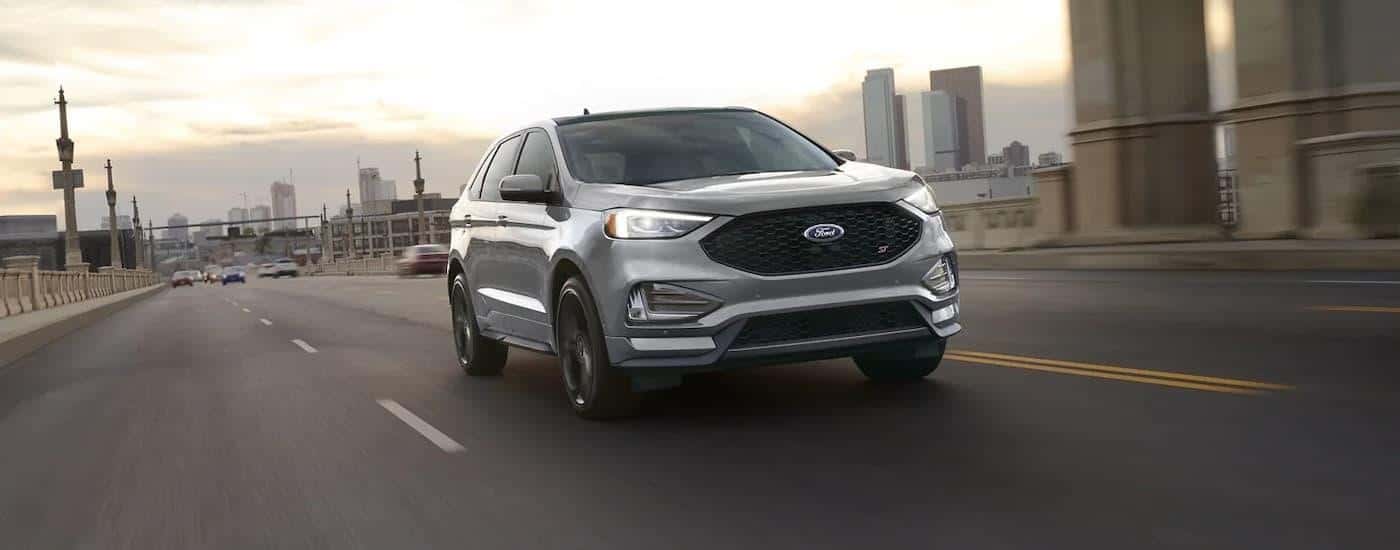 A silver 2023 Ford Edge ST is shown driving on a highway after leaving a Snellville Ford dealer.