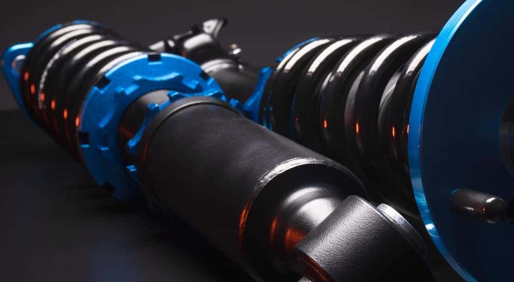 A close up of a vehicle's new struts during a replacement.