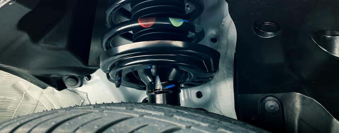 A close up of a strut on a vehicle that needs to be replaced.