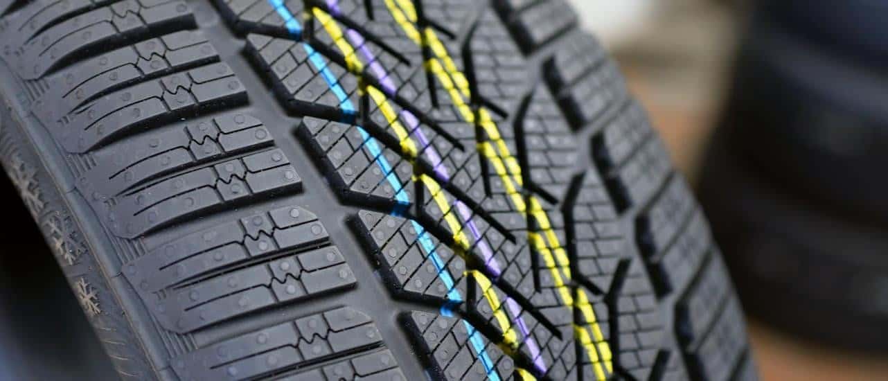 A close up of the treads on a new car tire.