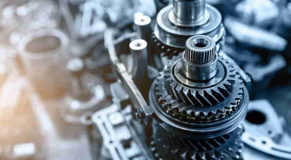 A close up shows transmission gears and a fork during a transmission repair.