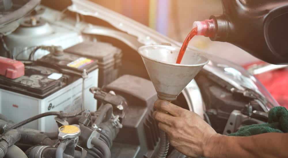 Transmission fluid being poured into a funnel.