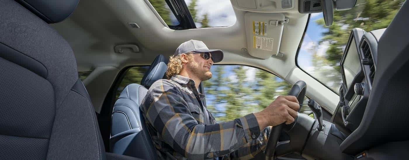 A man is shown driving in a 2022 used Ford Bronco Sport for sale.