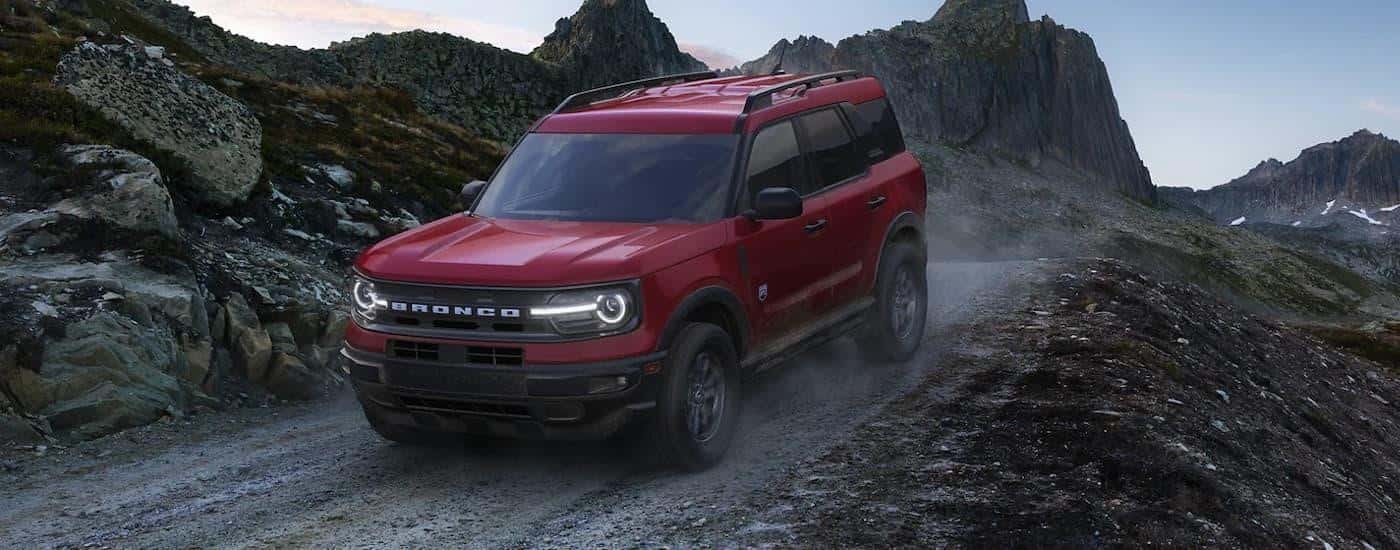 A red 2022 Ford Bronco Sport is shown off-roading on a mountain trail.