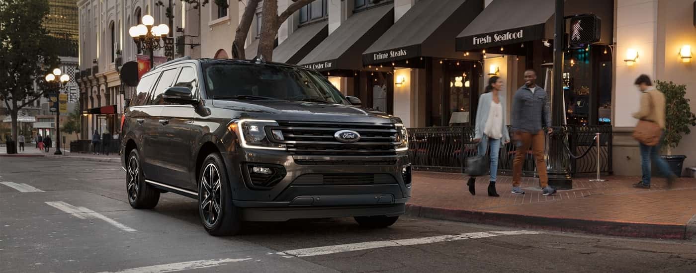 A black 2019 Ford Expedition Stealth Edition is shown on a city street after leaving a used Ford dealership.