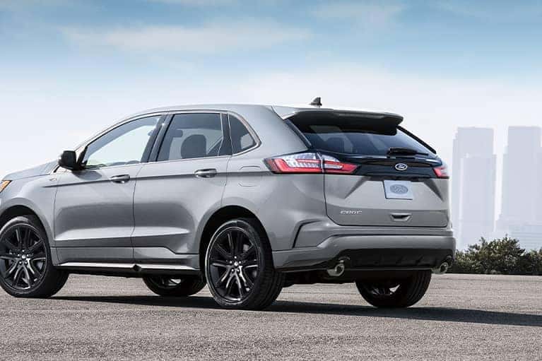 A silver 2021 Ford Edge parked with a cityscape in the background_mobile