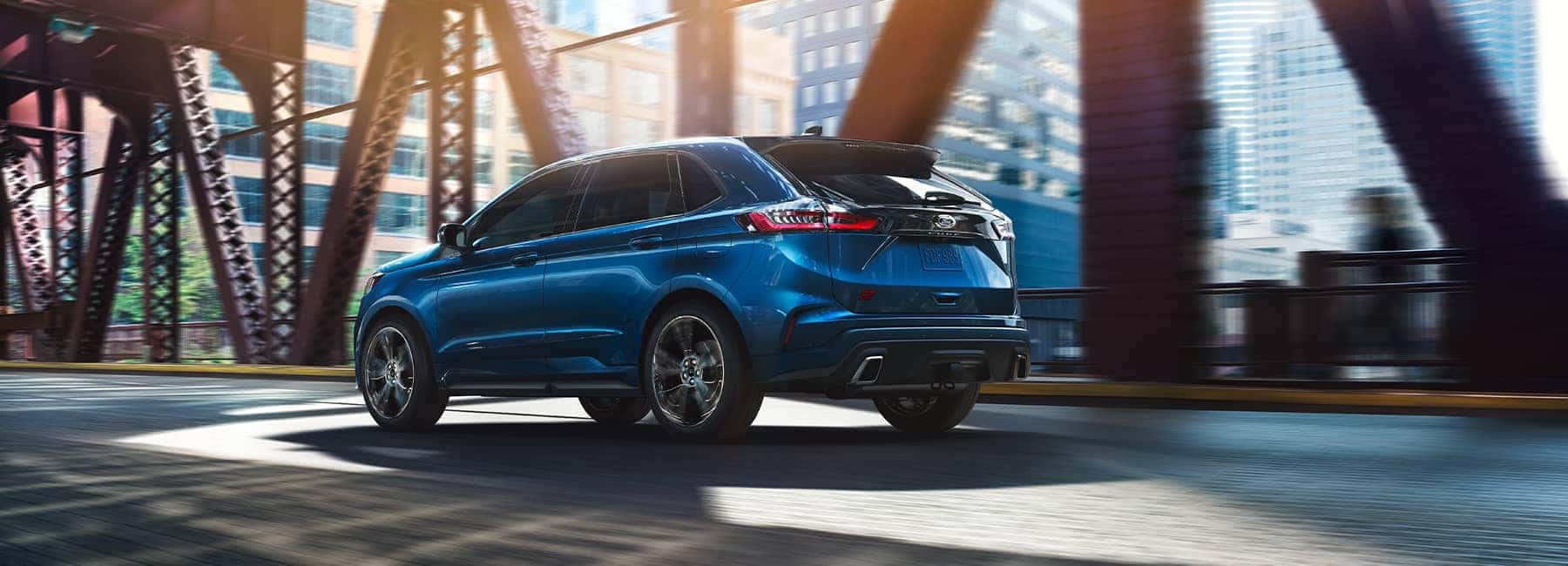 Blue 2021 Ford Edge crossing a city bridge