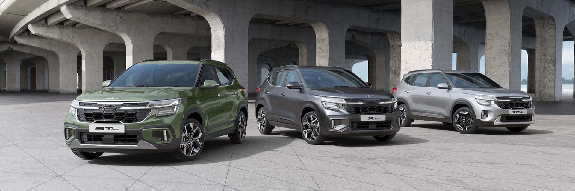 Kia vehicle lineup outside under a bridge.