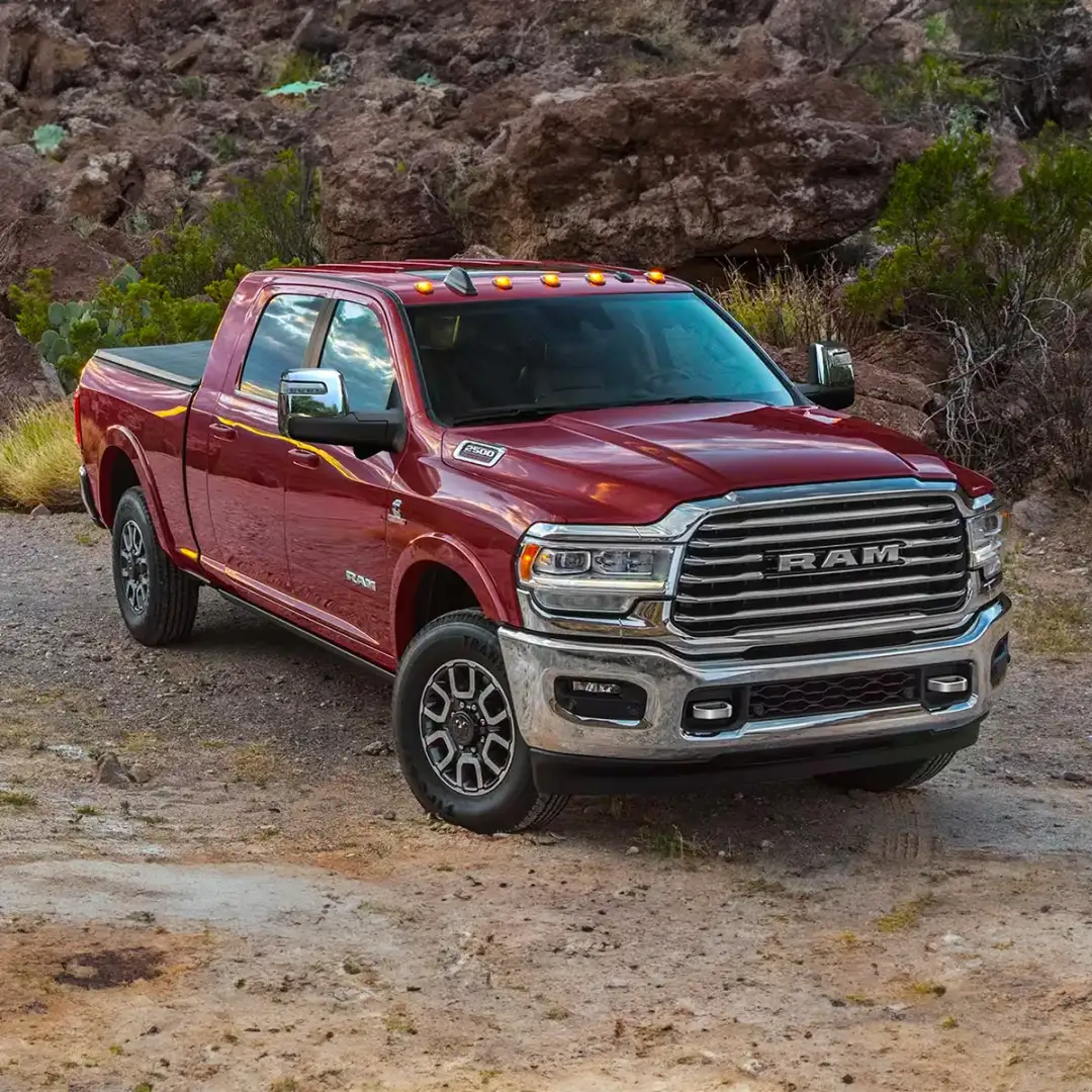 Front 3/4 shot of the 2024 RAM 2500 parked on dirt roadside during day.