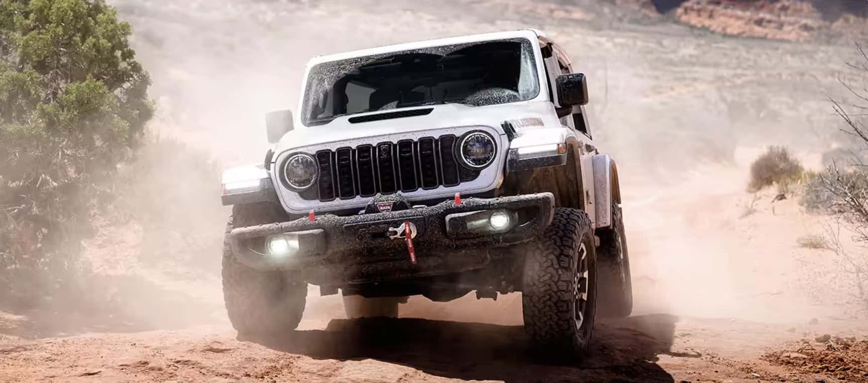 white-black-widow-wrangler drives rocky desert
