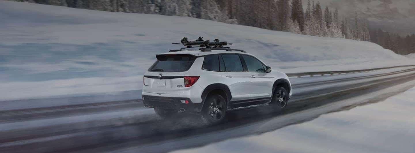 Honda driving along snowy mountain road