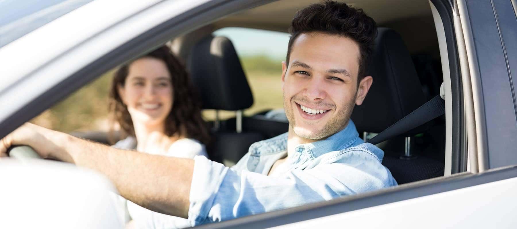 smiling man and woman in car