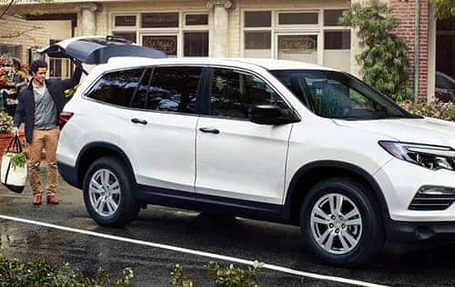 man loading groceries into the back of a Honda Pilot