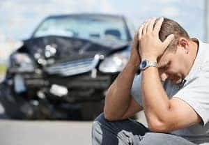 guy in front of a smashed car
