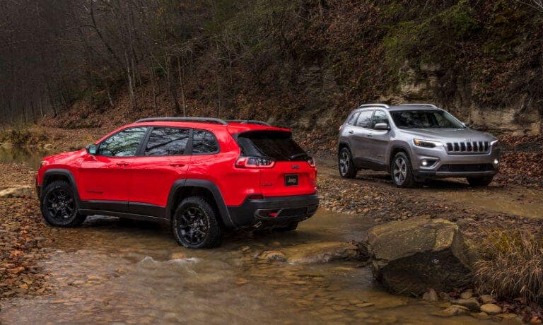 Two Jeep Cherokees off roading by a stream