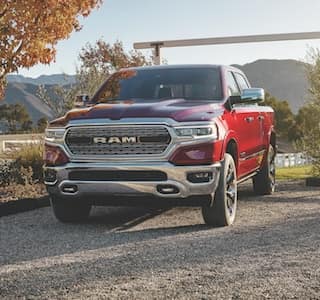 A red 2019 Ram 1500 driving on to a farm