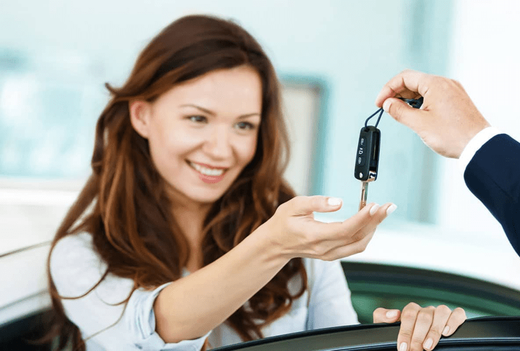happy woman receives car keys from car dealer - mobile