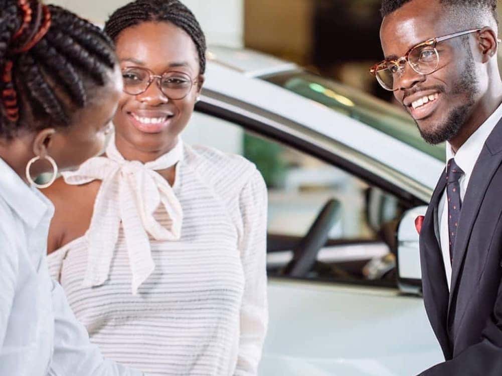 man is shaking hands with saleswoman and smiling