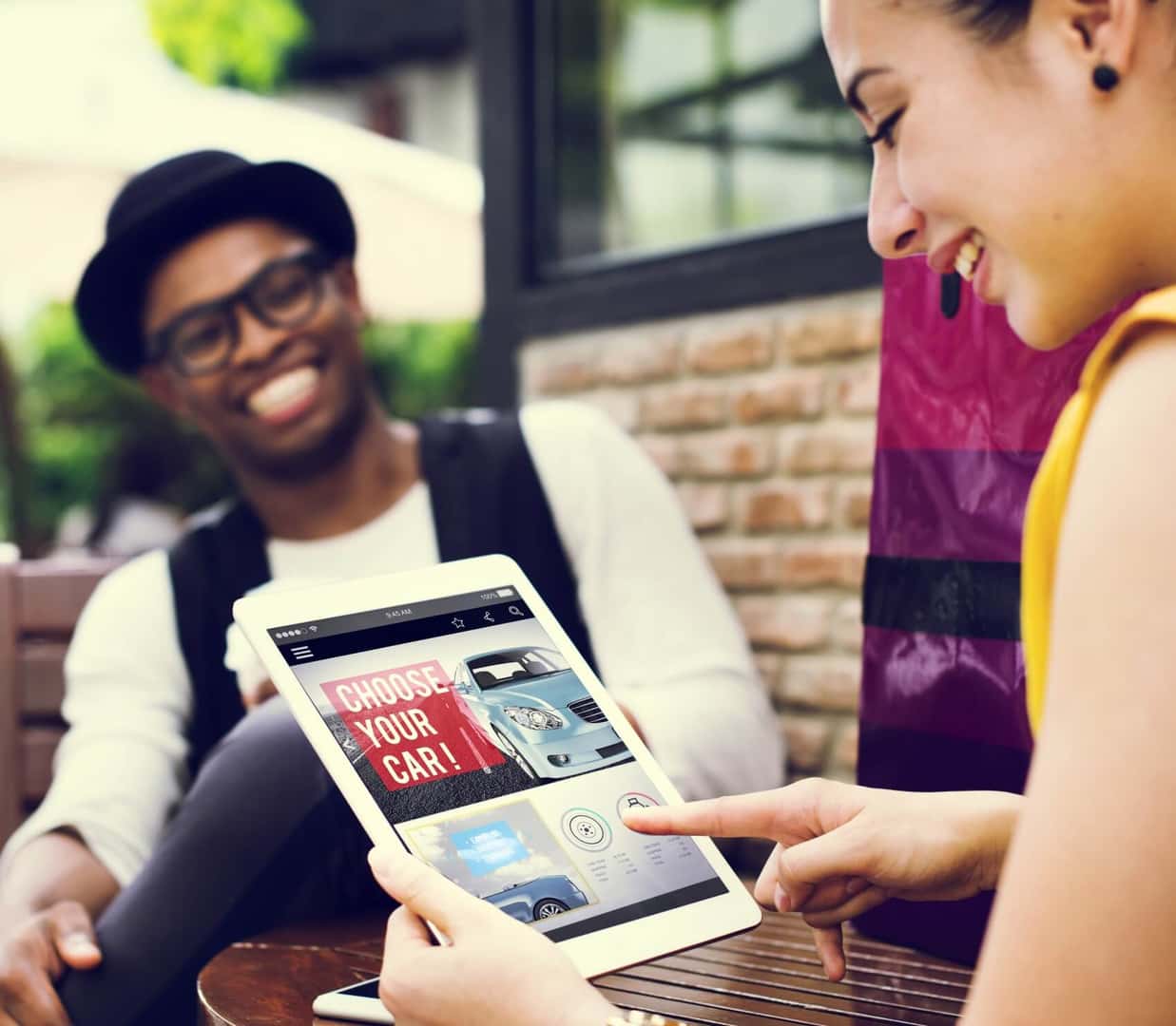 Two people car shopping online using a tablet