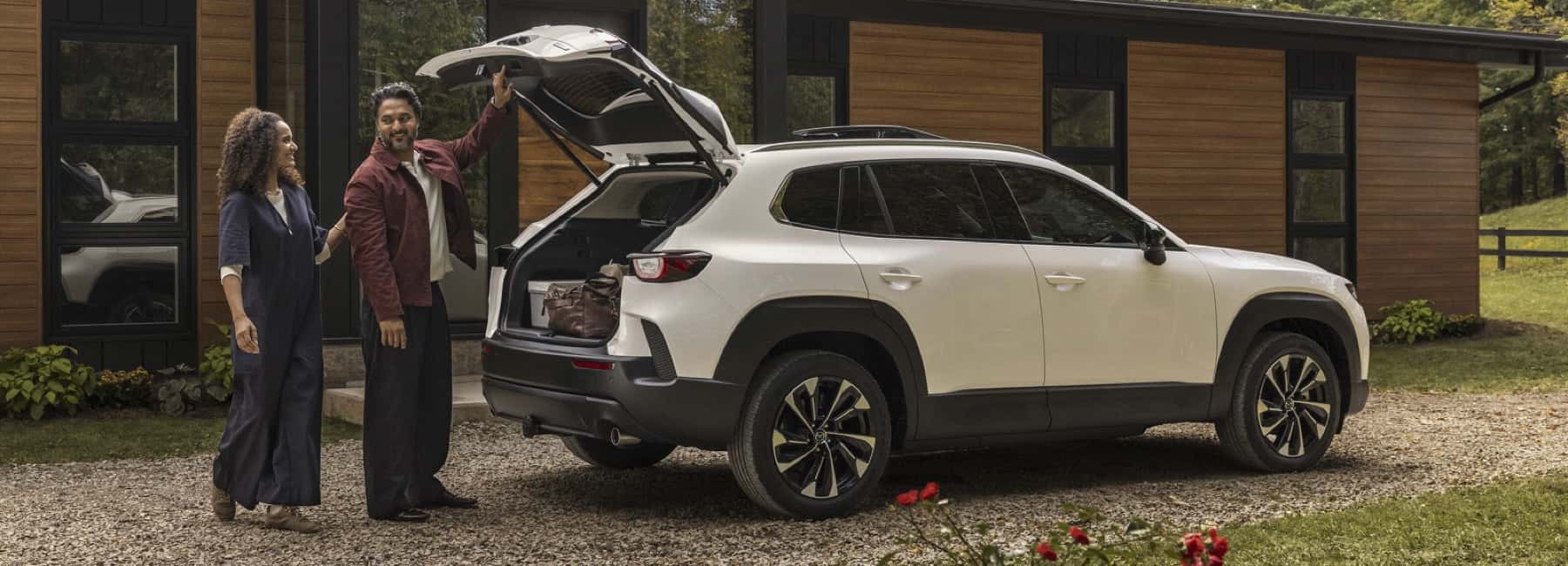 2026-Cx-50-Hybrid-parked-in-front-of-home-with-couple
