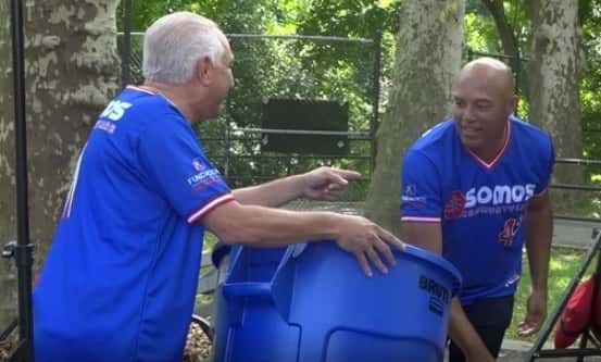 Two people moving trashcan