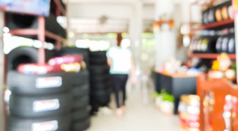 A blurry image shows a woman shopping in a Cincinnati, OH, tire shop.
