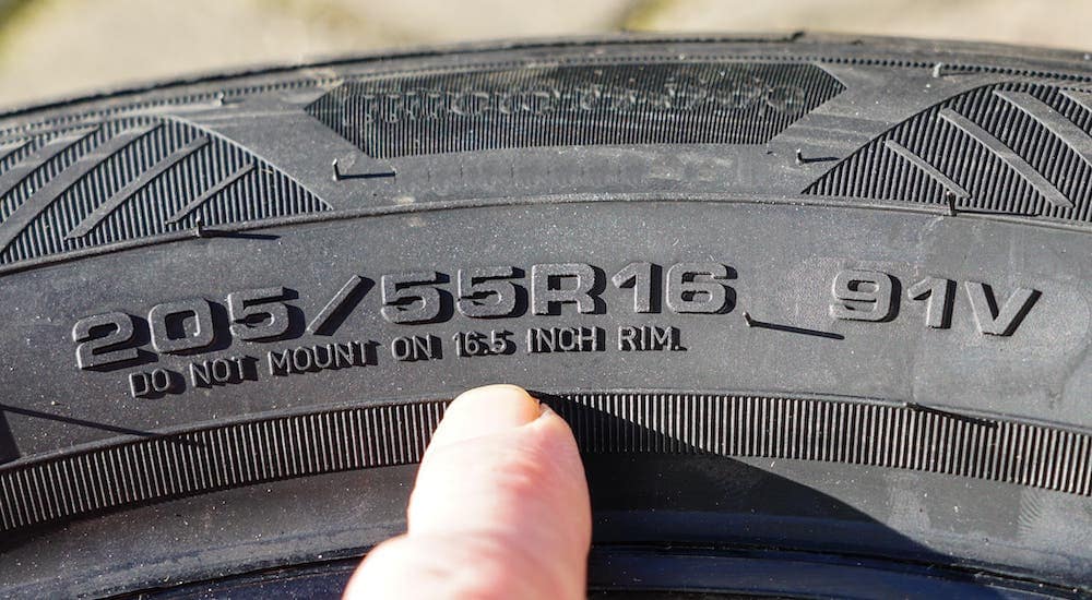 A finger is pointing to the code on the side of a tire, this will help you identify foreign or domestic brands.