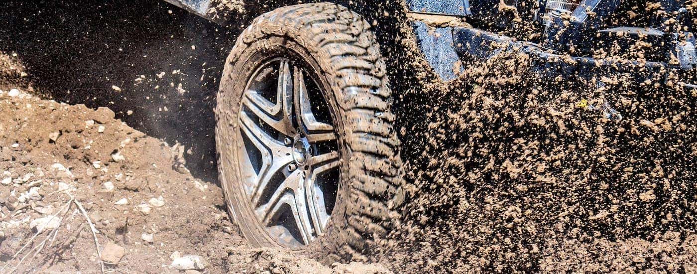 A closeup shows mud being kicked up under a blue truck near Cincinnati, OH.