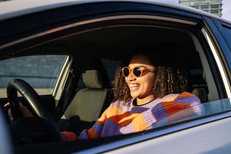 smiling woman driving vehicle