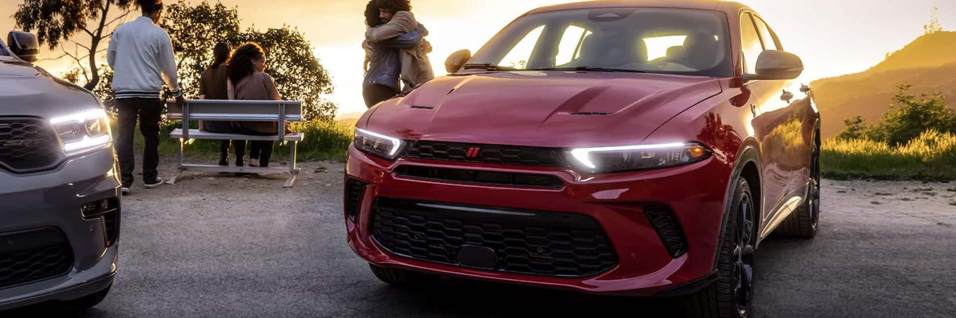 2024-Dodge-Hornet-parked-by-a-bluff-and-people-watching-the-sunset