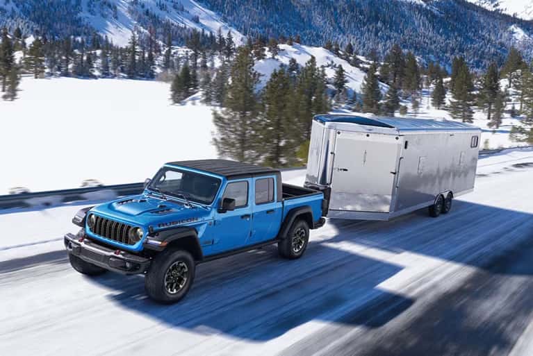 2025-Jeep-Gladiator-pulling-a-trailer-on-a-snowy-road