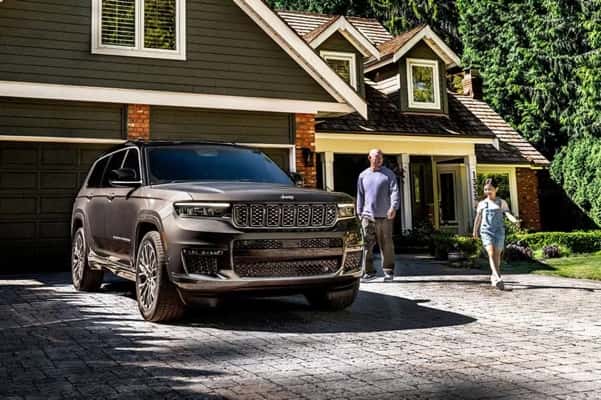 2025-Jeep-Grand-Cherokee-L-parked-in-front-of-a-large-expensive-looking-house