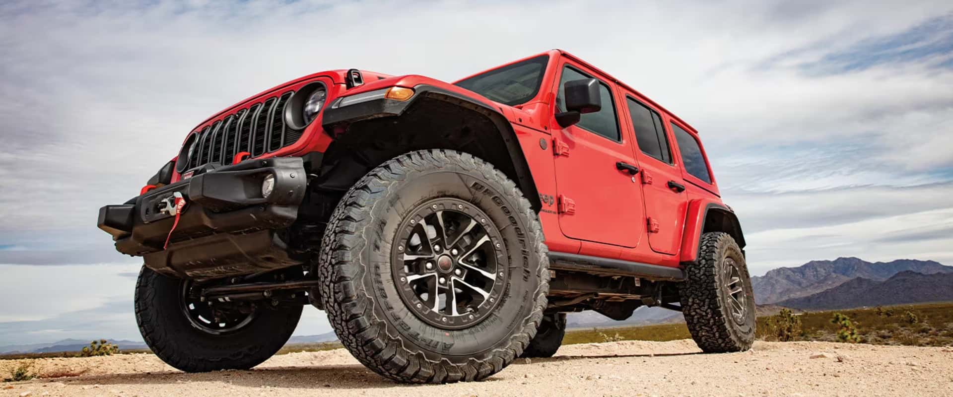 2025-Jeep-Wrangler-low-and-front-angle-with-mountains-in-the-background