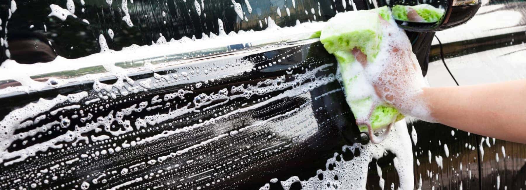 Door of a black car getting hand washed