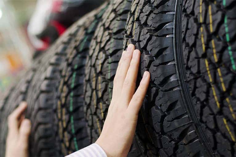 Hands Inspecting Tires in Tire Store