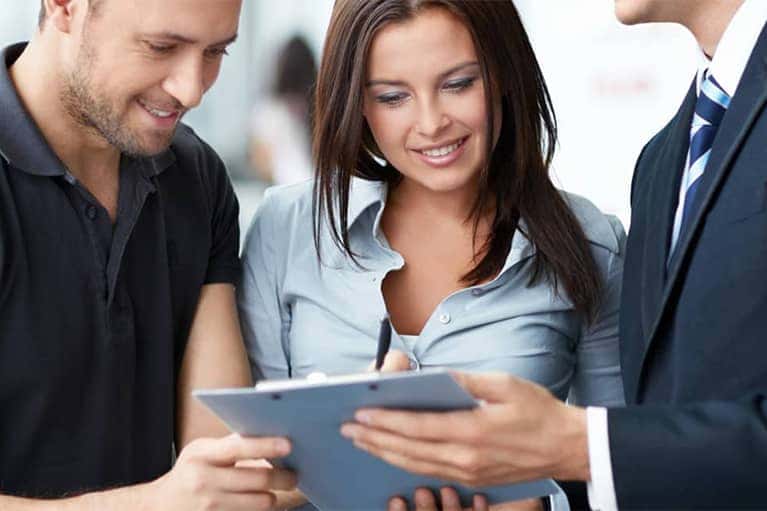 Man and a Woman Looking at Documents with Dealer