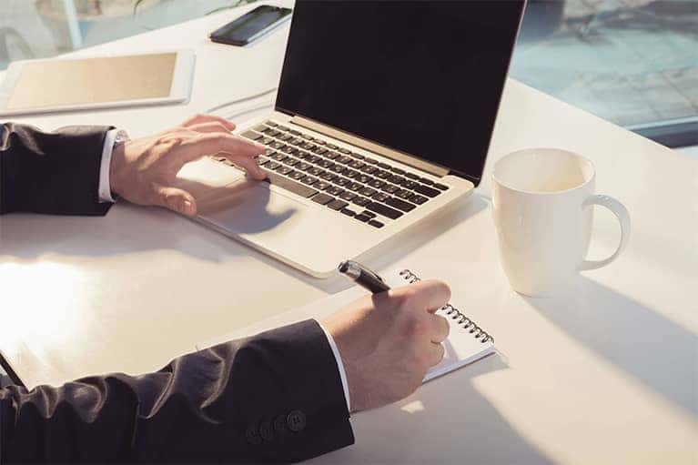 Businessman On Laptop Taking Notes