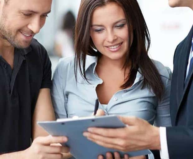 Man and a Woman Looking at Documents with Dealer