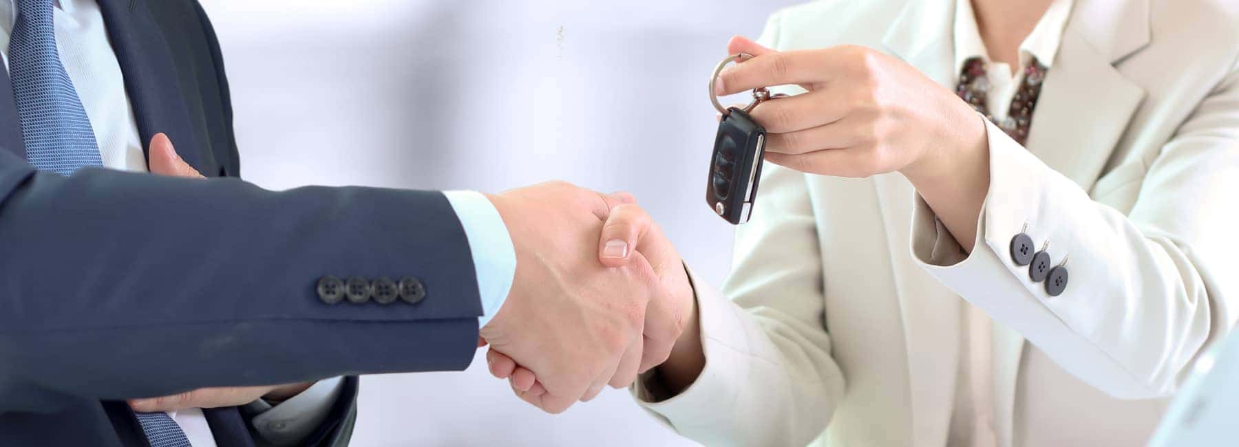 People shaking hands and handing over car keys
