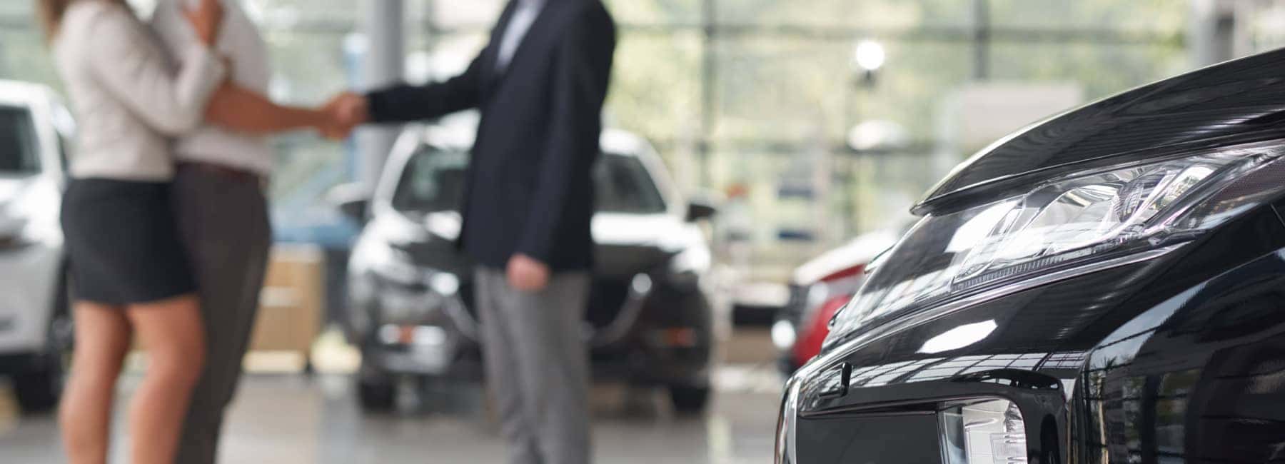 Two people shaking hands with a salesman
