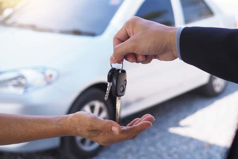 Hands of someone handing over car keys