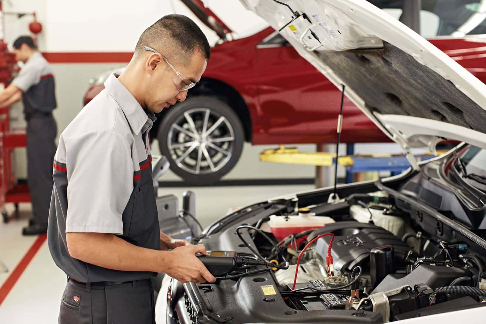 Toyota-service-technician-testing-a-battery