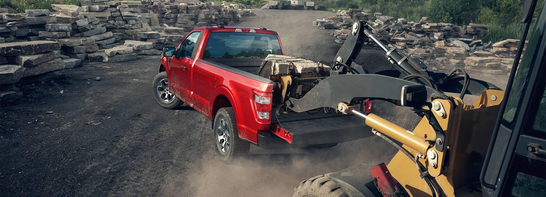 Red 2021 Ford F-150 hauling construction equipment