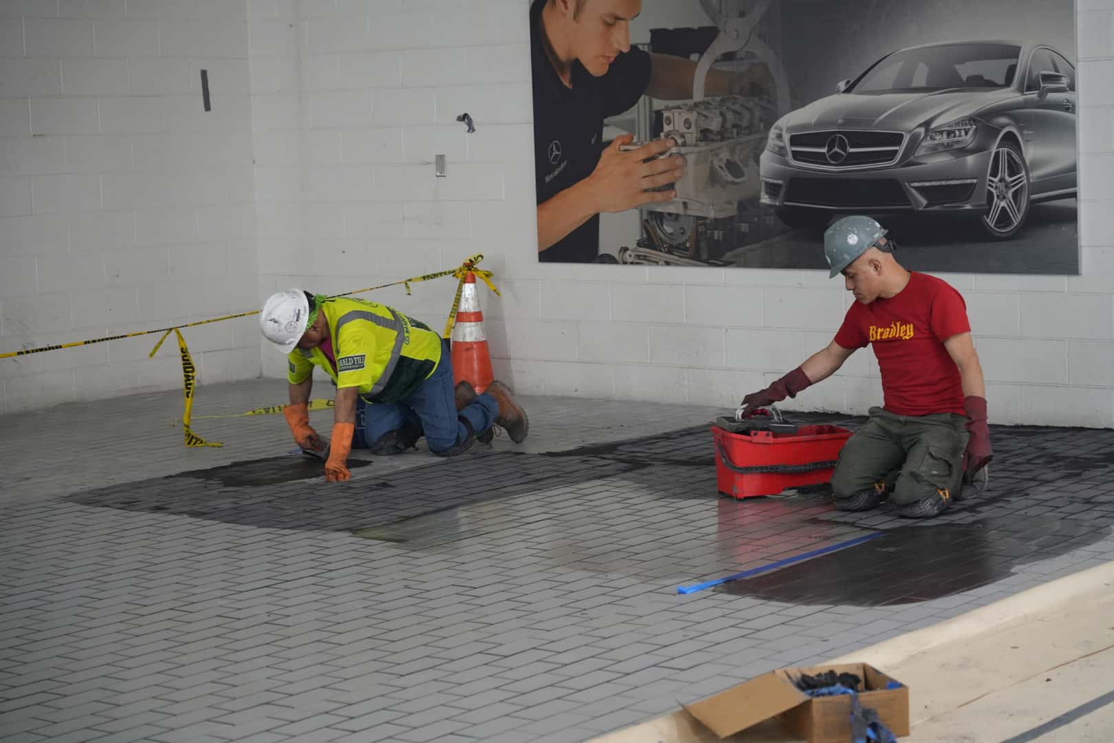 Mercedes-Benz of Manhattan Construction Workers putting in flooring
